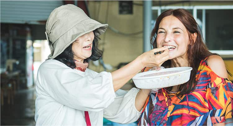 A woman feeding sea urchin to a woman