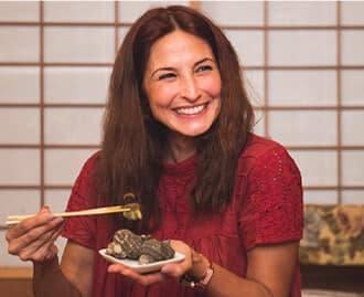 A woman lifting Sazae with chopsticks