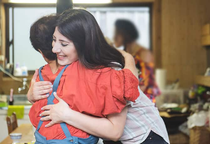 Kawachi-san and a woman hug each other