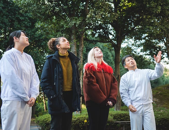 Mr Tanabe and Ms Sayaka and two women are looking up the wooden barrel