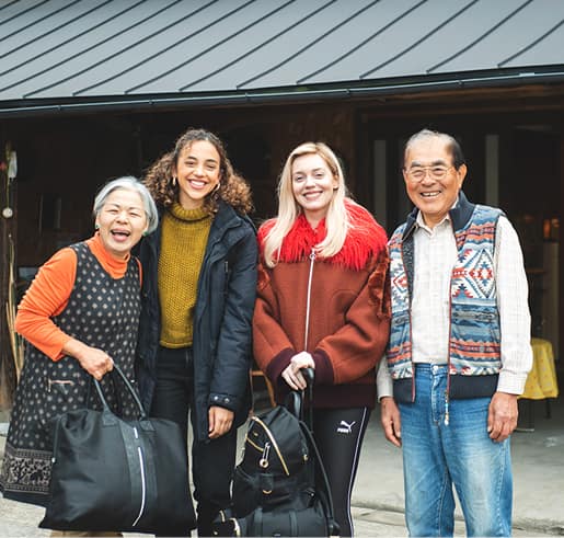 Mr and Mrs Aso and two women are smiling